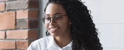 Mulher negra sorrindo olhando para o lado